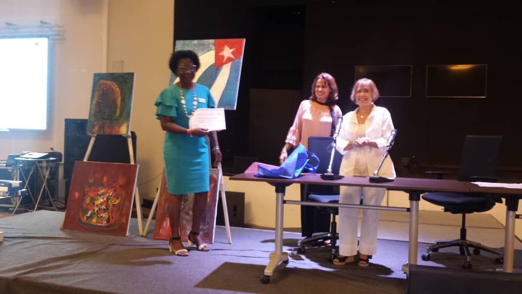 La doctora María Robinson (izq.), editora principal del libro, recibiendo personalmente el reconocimiento.